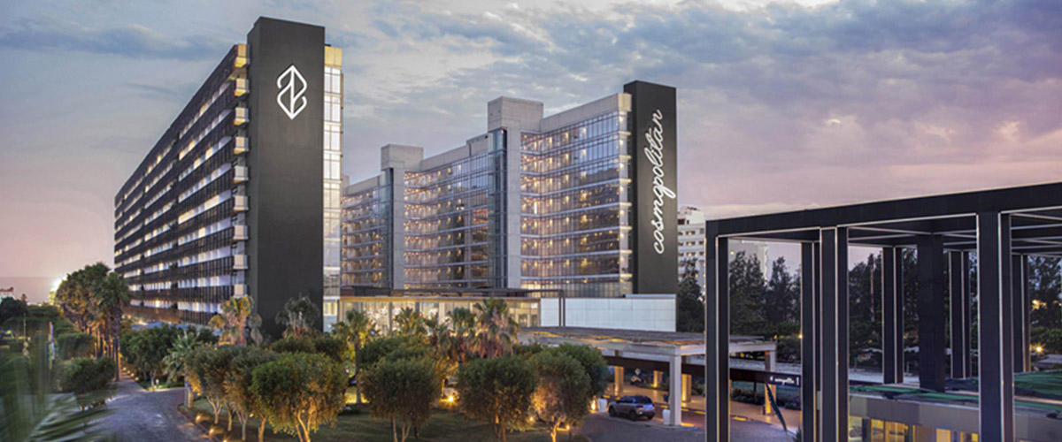 Nirvana Cosmopolitan Hotel stimmig beleuchtet bei bewölktem Himmel.