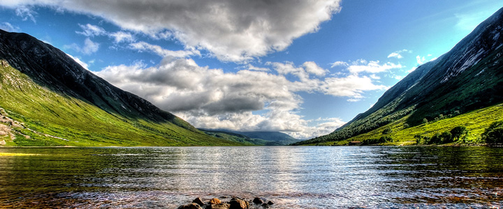 Loch Etive liegt eingebettet zwischen den schottischen Bergen. Das ruhige Wasser spiegelt die grünen Hänge und die weite, eindrucksvolle Landschaft.